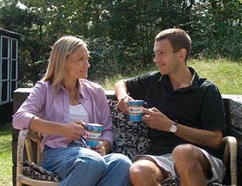 Paar trinkt Kaffee in der Sonne am Ferienhaus